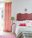 <p> A bedroom is an ideal space to play with pattern. The exuberant headboard is the focal point here, with its wonderfully wavy design and fabulously bright and bold fabric. Then the eye is invited to take in the dynamic, diagonal striped curtains, the colourful bedside lamp, patterned quilt and cushion, and finally the pink woven flatweave rug. All work together to complement the overall joyful scheme.  </p> <p> White tongue and groove panelling is a simple way to add a country feel to a space. This combined with all the color and pattern makes for a very upbeat and contemporary feeling country bedroom, especially if you are lucky enough to be able to open the doors out onto the prettiest of gardens, on a summer's morn.  </p> <p> <br> </p> <p> <br> </p>