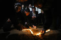 Israelis light candles in memory of seven Israelis killed by a Palestinian gunman Friday at the site of the shooting attack in east Jerusalem, Saturday, Jan. 28, 2023. On Friday the gunman opened fire outside a synagogue, killing seven people, including a 70-year-old woman, and wounding three others before he was shot and killed by police, officials say. It was the deadliest attack on Israelis since 2008 and raised the likelihood of more bloodshed. (AP Photo/Ariel Schalit)