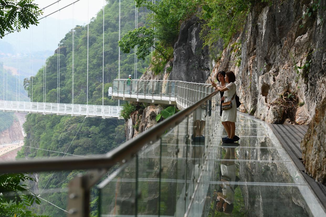 people stand on the Bach Long glass bridge in the Moc Chau district in Vietnam's Son La province
