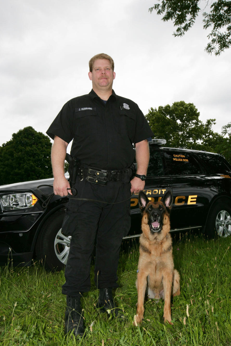 IMAGE DISTRIBUTED FOR PETARMOR - In this photo taken on Wed., July 16, 2014 in Detroit, police officer Jedadiah Hubbard is seen with his dog, Diesel, in the Detroit Police K9 training field. PetArmor has donated bullet-and-stab-protective vests to three K-9s who work alongside officers in the Detroit Police Department. (Photo by Gary Malerba/Invision for PetArmor/AP Images)