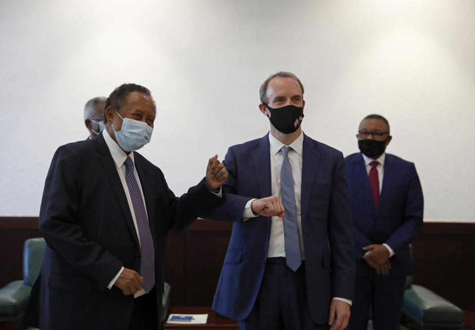 Sudanese Prime MInister Abdullah Hamdok, right, bumps elbows with British Foreign Secretary, Dominic Raab in the Cabinet Building, in Khartoum, Sudan, Thursday, Jan. 21, 2021. Raab was in the Sudanese capital Thursday to discuss bilateral relations and tensions along the border with Ethiopia, Sudan's state news agency reported. (AP Photo)