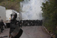 A cloud of teargas rises as Guatemalan soldiers and police clash with migrants at a roadblock on the highway in Vado Hondo, Guatemala, Monday, Jan. 18, 2021. The roadblock was strategically placed at a chokepoint on the two-lane highway flanked by a tall mountainside and a wall leaving the migrants with few options. (AP Photo/Sandra Sebastian)