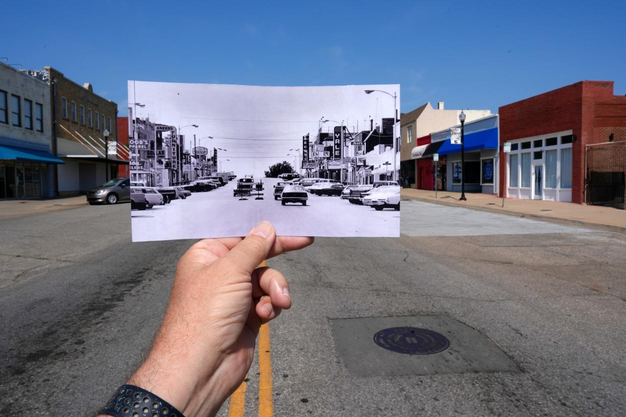 Oklahoman photo editor Doug Hoke holds up a 1977 photo he took of SW 25, previously known as Commerce Street, for comparison to present day Capitol Hill.