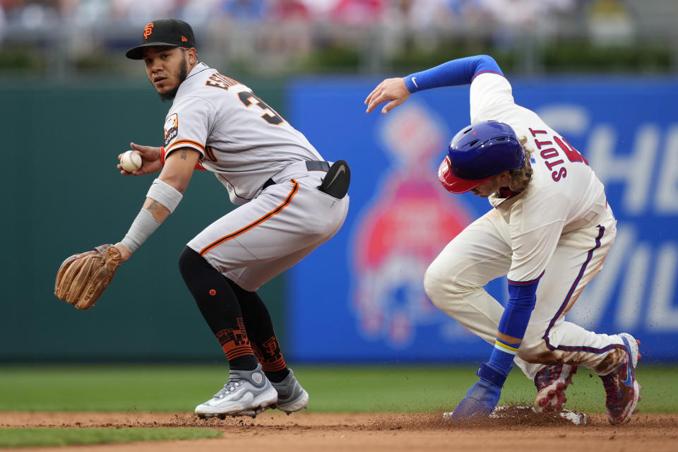 San Francisco Giants second baseman Thairo Estrada, left, looks to first after forcing out Philadelphia Phillies' Bryson Stott at second on a fielder's choice hit into by J.T. Realmuto during the fifth inning of a baseball game, Wednesday, Aug. 23, 2023, in Philadelphia. (AP Photo/Matt Slocum)