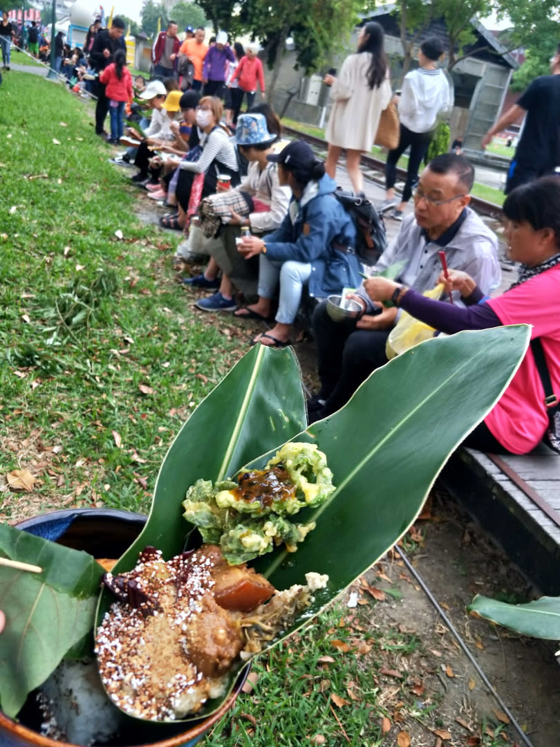 人們席地而坐，店家以樹葉當餐盤盛裝美食，相當環保又接地氣。（圖／高靜玉攝）  