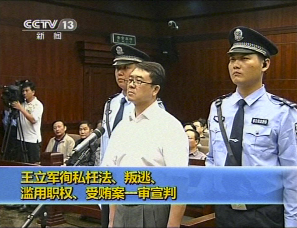 In this Sept. 24, 2012 video image taken from CCTV, Wang Lijun, center, stands while the verdict is announced during his trial at the Intermediate People's Court in Chengdu, in southwestern China's Sichuan province. The Chinese police chief whose thwarted defection exposed murder and infighting in high places was sentenced to 15 years in prison Monday, Sept. 24, 2012, setting the stage for China's leadership to close out the divisive scandal and move ahead with a generational handover of power. (AP Photo/CCTV via AP video) CHINA OUT, TV OUT