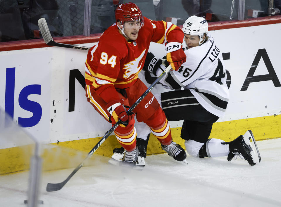 Los Angeles Kings forward Blake Lizotte (46) is checked by Calgary Flames defenseman Brayden Pachal (94) during the second period of an NHL hockey game, Tuesday, Feb. 27, 2024 in Calgary, Alberta. (Jeff McIntosh/The Canadian Press via AP)