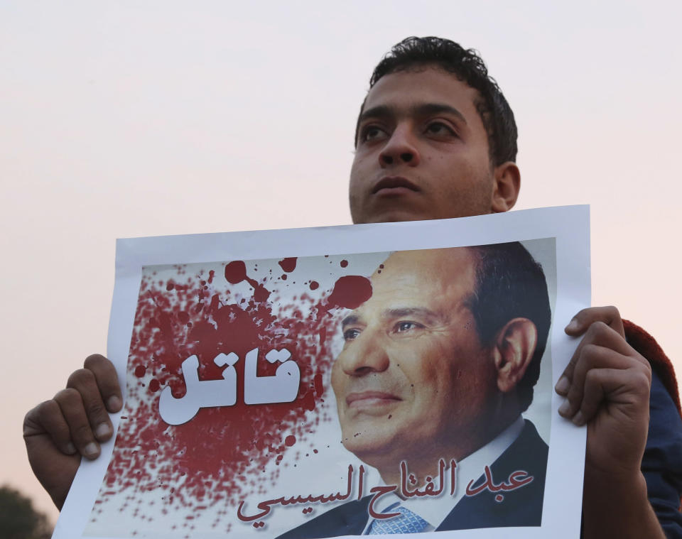 Un hombre sujeta un poster de Al-Sisi en el que se lee la palabra 'asesino'. (AP).