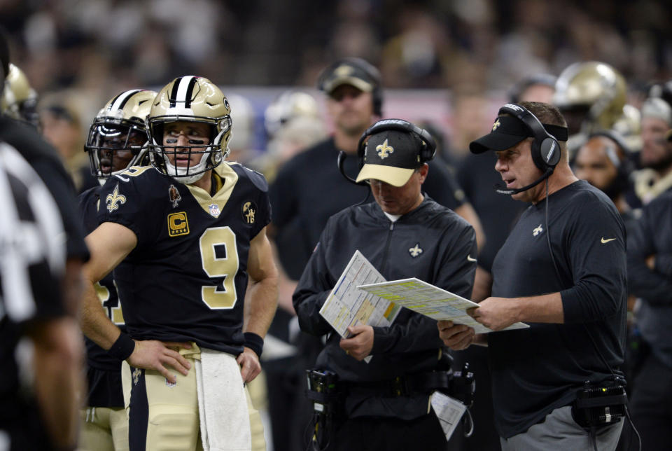 FILE - New Orleans Saints quarterback Drew Brees (9) talks with head coach Sean Payton, right, and offensive coordinator Pete Carmichael in the second half of an NFL football game against the Tampa Bay Buccaneers in New Orleans, Sunday, Sept. 9, 2018. This weekend in Atlanta, the Saints debut an offense now run exclusively by long-time Payton understudy Pete Carmichael Jr. (AP Photo/Bill Feig, File)