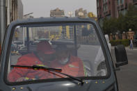 Municipal workers sit in a three-wheeled bike on the street in Beijing, China, March 21, 2024. China’s first generation of migrant workers played an integral role in the country's transformation from an impoverished nation to an economic powerhouse. Now, they're finding it hard to find work, both because they're older and the economy is slowing. (AP Photo/Tatan Syuflana)