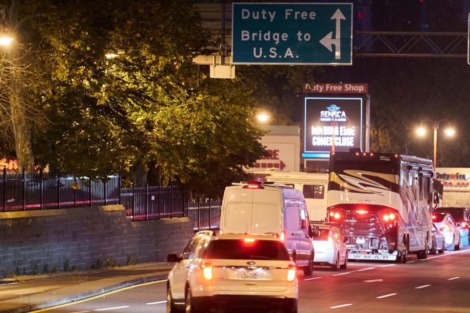 Canadian travelers wait in line to cross the border into the United States across the Rainbow Bridge in Niagara Falls, Ontario, early November 8, 2021.