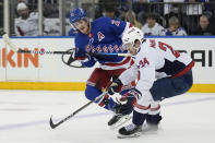 Washington Capitals' Connor McMichael, right, and New York Rangers' Adam Fox compete for the puck during the first period in Game 1 of an NHL hockey Stanley Cup first-round playoff series, Sunday, April 21, 2024, in New York. (AP Photo/Seth Wenig)