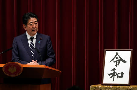 Japan's Prime Minister Shinzo Abe delivers a press conference standing next to the calligraphy 'Reiwa' which was chosen as the new era name at the prime minister's office in Tokyo, Japan, April 1, 2019. Franck Robichon/Pool via Reuters