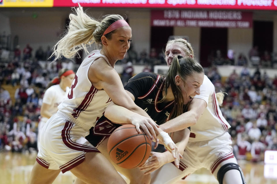 Nebraska's Isabelle Bourne, center, is trapped by Indiana's Sydney Parrish, left, and Lexus Bargesser during the first half of an NCAA college basketball game, Sunday, Jan. 1, 2023, in Bloomington, Ind. (AP Photo/Darron Cummings)