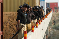 Police watch as supporters of Pakistani opposition leader Imran Khan shout slogans at a spot where police blocked the highway with shipping containers in Swabi, between Peshawar and Islamabad, Pakistan October 31, 2016. REUTERS/Fayaz Aziz