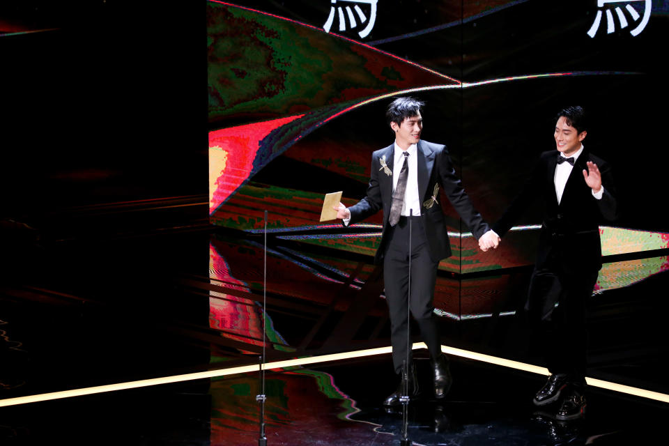 范少勳（左）與身穿Dior晚宴服的港星劉俊謙（右）手牽手上台頒獎。