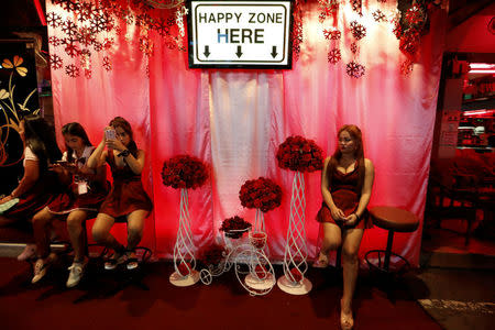 Women sits outside a go-go dance bar in Pattaya, Thailand March 25, 2017. Picture taken March 25, 2017. REUTERS/Jorge Silva