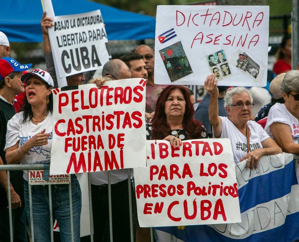 MIAMI, FL- March 19, 2023 - Demonstrators hold signs and shout slogans to protest the the game between the United States and Cuba in front of loanDepot Park prior to the baseball game.