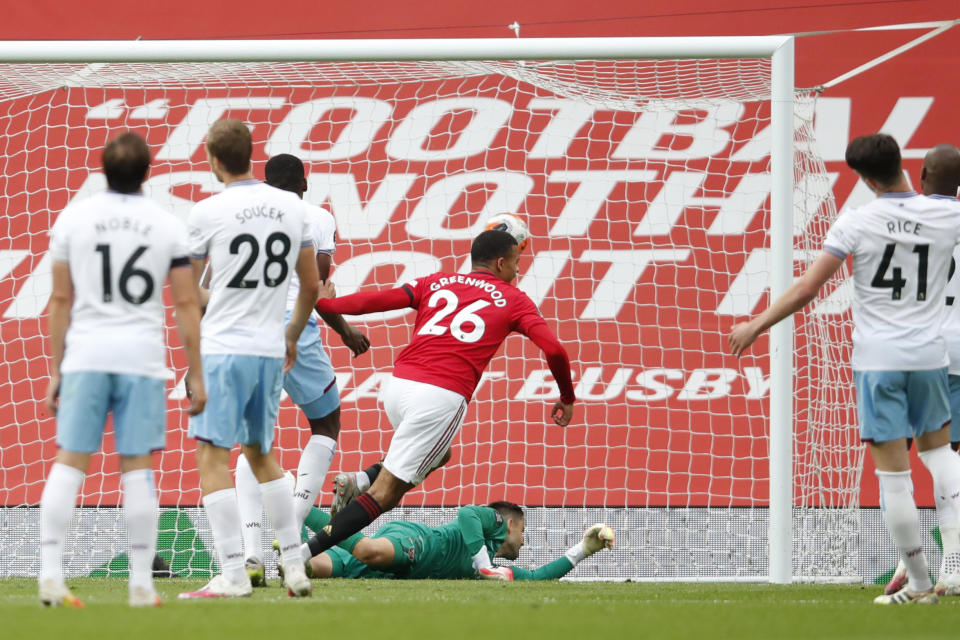 Manchester United's Mason Greenwood scores his side's opening goal during the English Premier League soccer match between Manchester United and West Ham at the Old Trafford stadium in Manchester, England, Wednesday, July 22, 2020. (Clive Brunskill/Pool via AP)