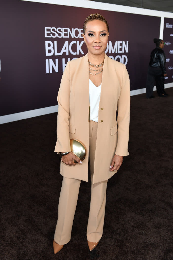 MC Lyte in a relaxed pantsuit and holding a clutch