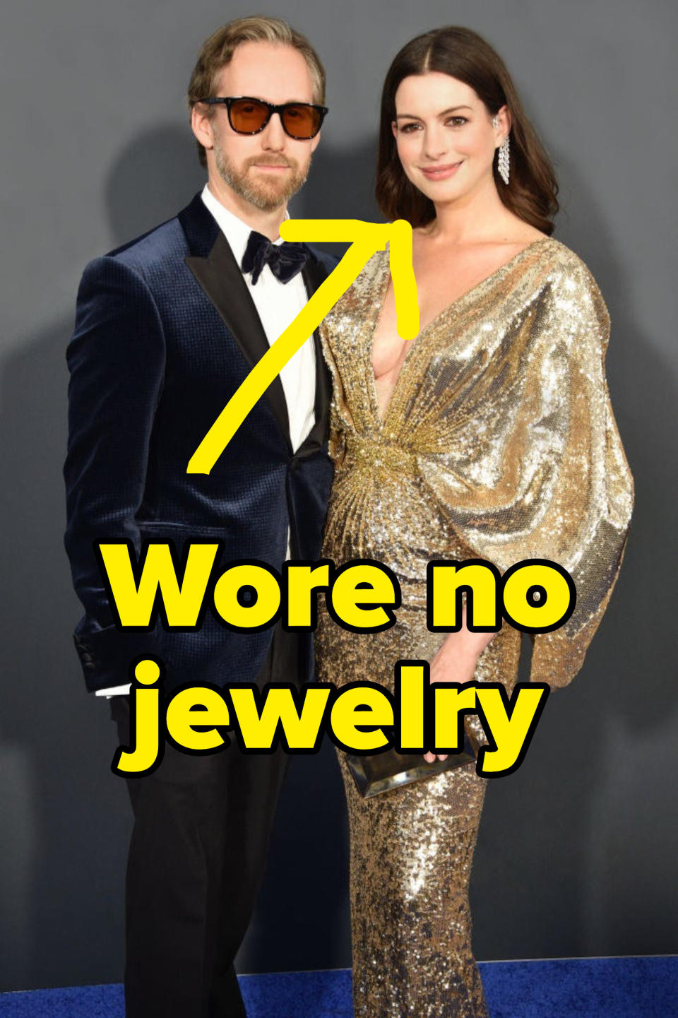 Picture of Anne Hathaway and Adam Shulman at a red carpet with text pointing at Hathaway reading "wore no jewelry"