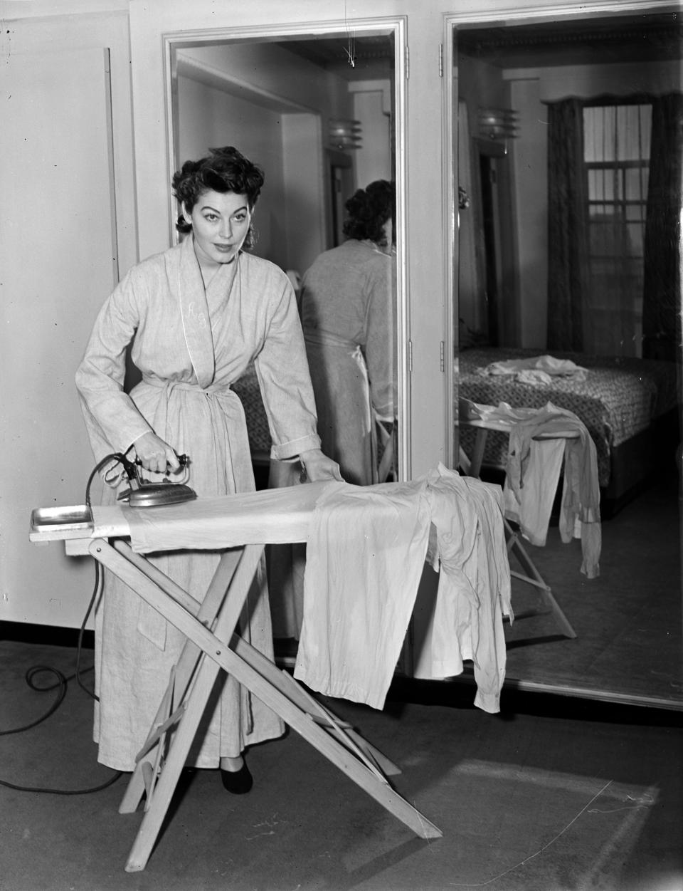Gardner takes a break from the glitter to iron her pajamas in this 1950 photo.