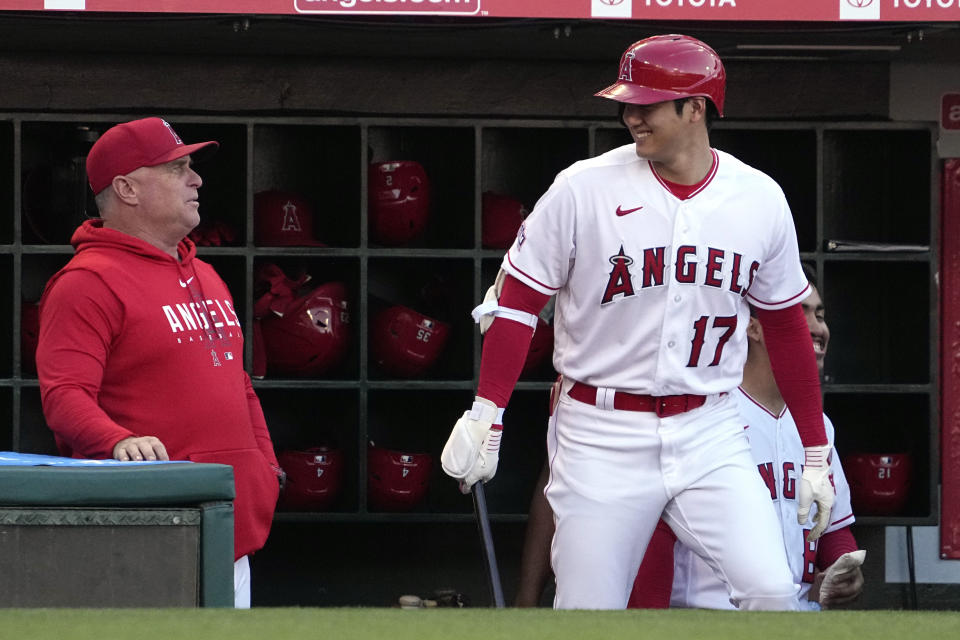 Los Angeles Angels' Shohei Ohtani, right, smiles at manger Phil Nevin as he steps out of the dugout to bat during the first inning of a baseball game against the Chicago White Sox Wednesday, June 28, 2023, in Anaheim, Calif. (AP Photo/Mark J. Terrill)