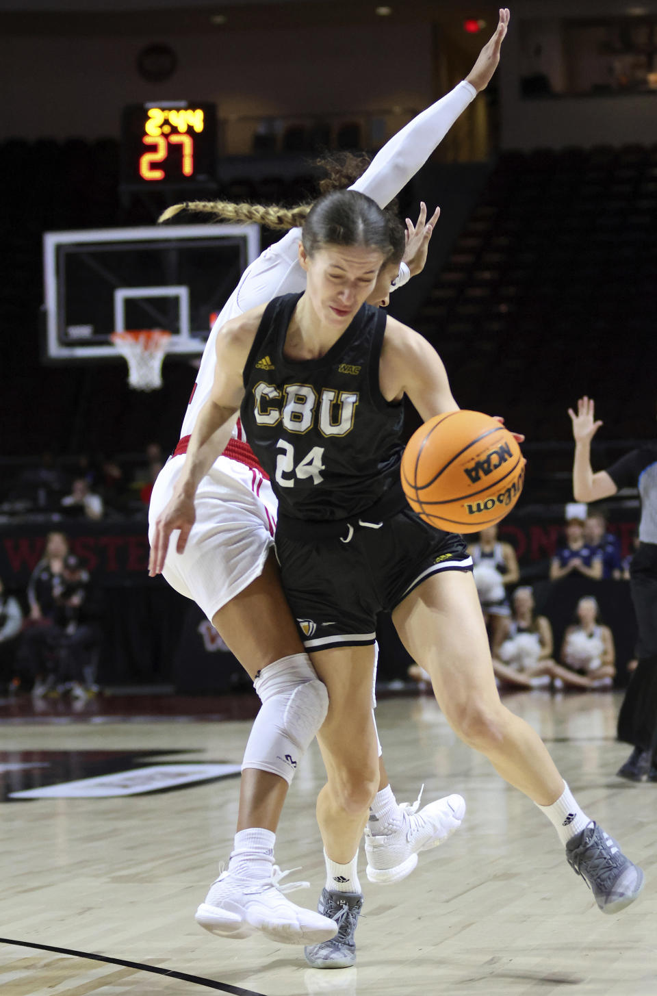 California Baptist guard Brittany Klaman (24) and Southern Utah guard Tomekia Whitman (2) collide during the first half of an NCAA college basketball game in the championship of the Western Athletic Conference tournament, Saturday, March 11, 2023, in Las Vegas. (AP Photo/Ronda Churchill)