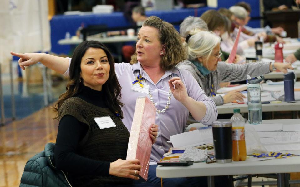 Exeter ballot clerks Vanessa Lazar, left, and Cheryl Turner Elwell work at the polls Tuesday, March 8, 2022.