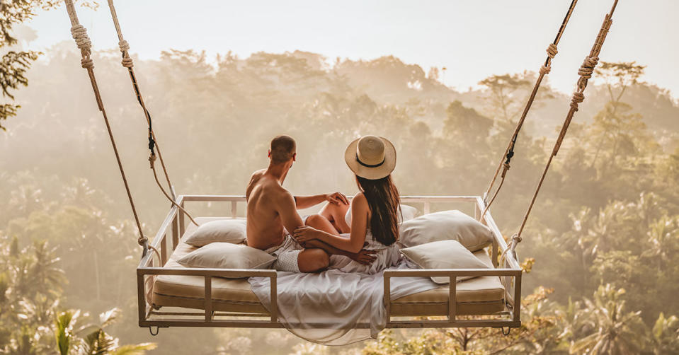 A couple sitting on a bed swing in Bali, Indonesia