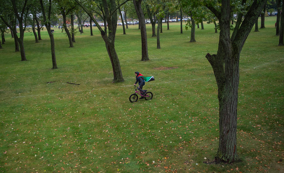 DEARBORN, MICHIGAN - OCTOBER 14: A person rides a bike with a Palestinian flag during a march in support of Palestinians on October 14, 2023 in Dearborn, Michigan. Dearborn is home to one of the largest populations of Arabs and Arab diaspora in the US, with many of the community who have family and friends currently living in Gaza and Palestine. Pro-Palestinian protesters gathered across the country today as Israel prepares for an expected ground offensive in Gaza. (Photo by Matthew Hatcher/Getty Images)