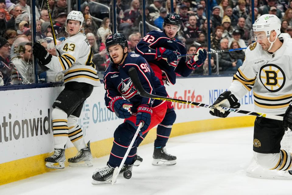 Jan 2, 2024; Columbus, Ohio, USA; Columbus Blue Jackets center Jack Roslovic (96) reaches for a puck ahead of Boston Bruins defenseman Kevin Shattenkirk (12) during the first period of the NHL hockey game at Nationwide Arena.