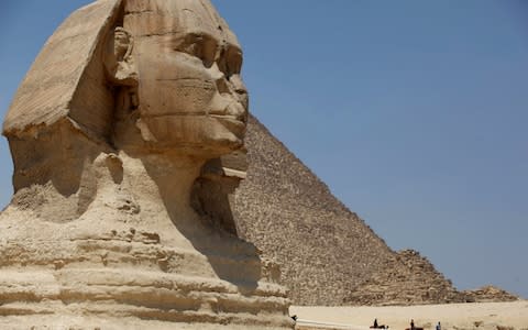Tourists ride horses past the Great Sphinx at the historical site of the Giza Pyramids, near Cairo, Egypt - Credit:  Jon Gambrell