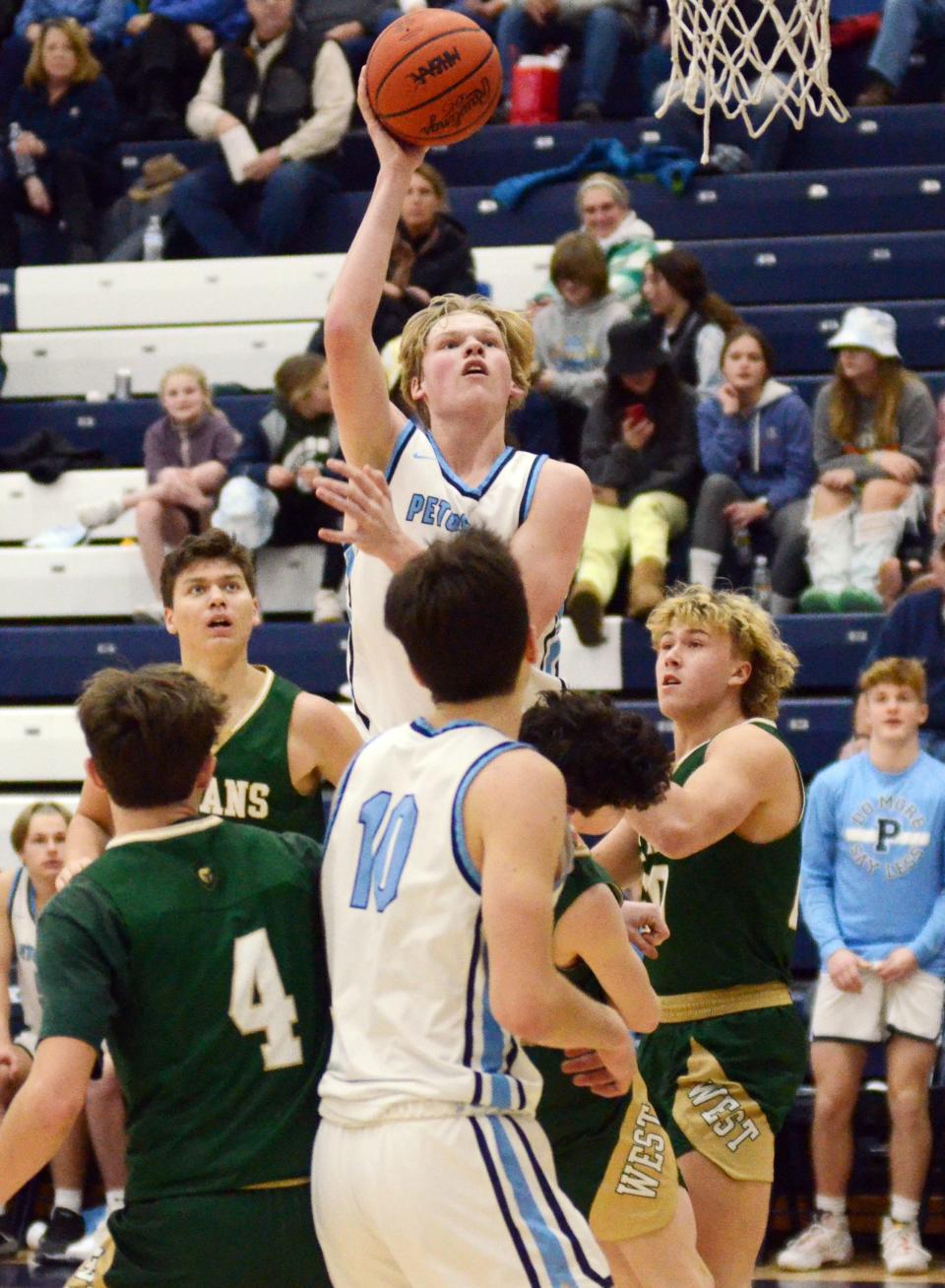 Petoskey's Cade Trudeau drives and elevates for a basket against the Titans in the second half.