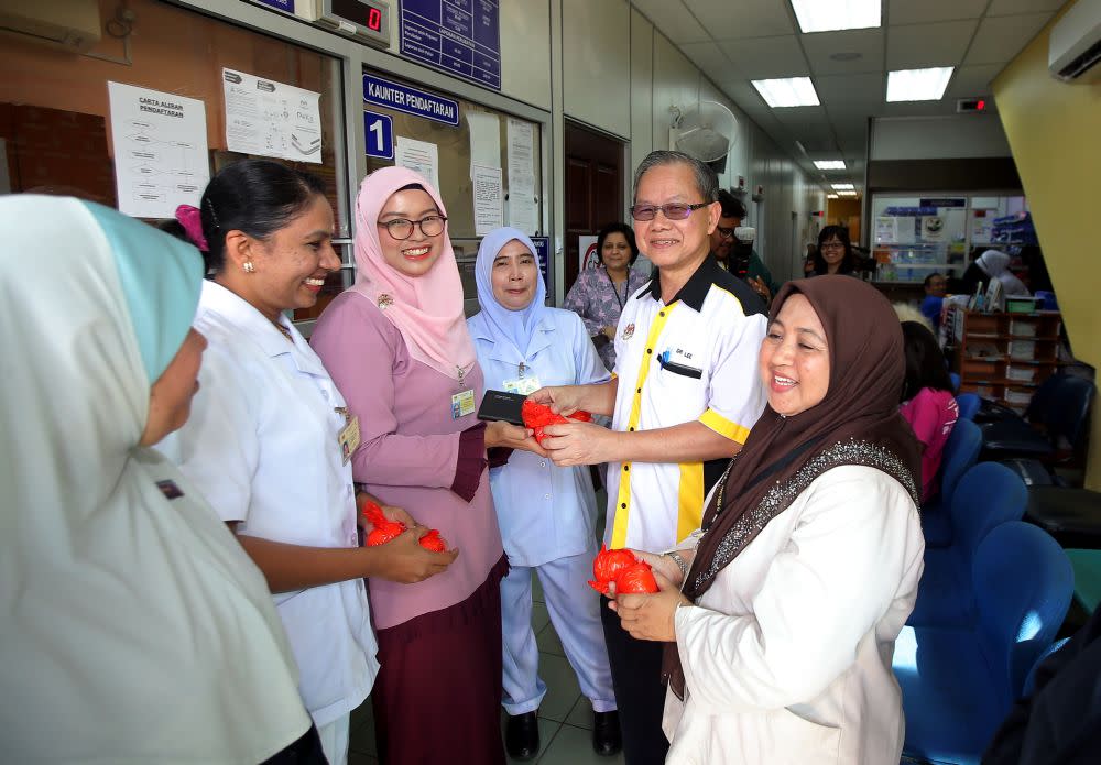 Deputy Health Minister Dr Lee Boon Chye distributes mandarin oranges to staff at the Bijih Timah Health Clinic in Ipoh January 17, 2020. — Picture by Farhan Najib