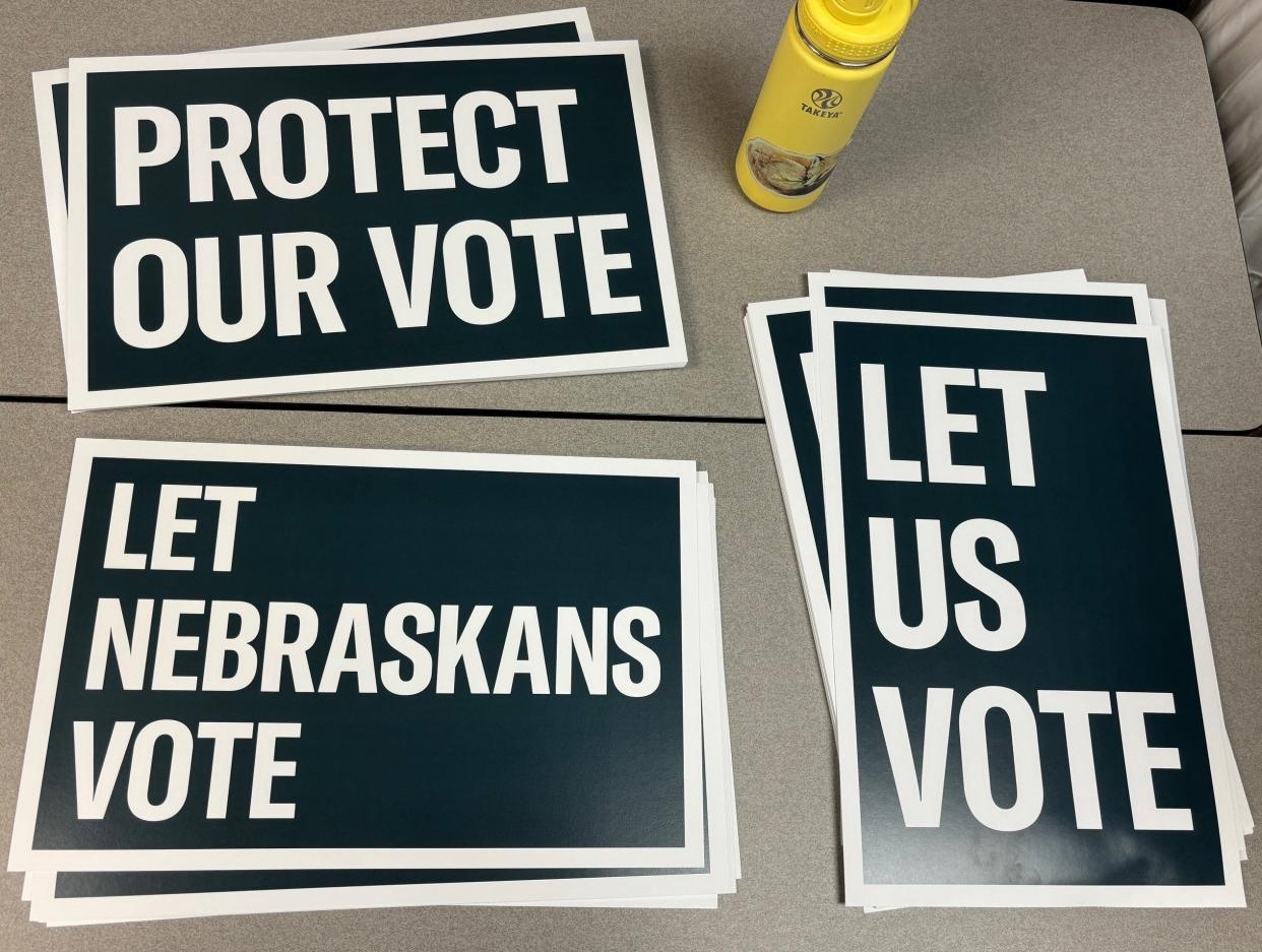 Stacks of signs sit on a table at a press conference in Lincoln, Neb. Monday where Civic Nebraska and the Nebraska ACLU announced a lawsuit against the secretary of state.