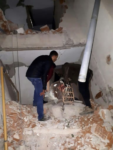 Men stand on rubble of a collapsed building after a 6.8 magnitude earthquake in Elazig, eastern Turkey on January 24, 2020, killing several people; The quake shook the Sivrice district in the eastern province at around 8.55 pm (1755 GMT)