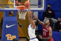 Pittsburgh's Noah Collier, left, tries to dunk as Louisville's David Johnson (13) defends during the first half of an NCAA college basketball game Tuesday, Dec. 22, 2020, in Pittsburgh. (AP Photo/Keith Srakocic)