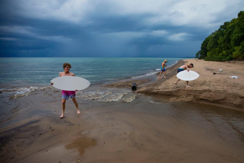 Coleman Schroeder, from left, Drew Holub and Jacob Barbour skimboard a few years ago at Cherry Beach in Harbert.