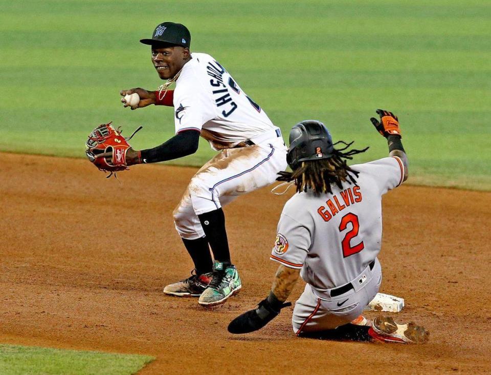 Miami Marlins Jazz Chisholm Jr. second baseman (21) prepares to throw to first base as Baltimore Orioles Freddy Galvis (2) slides into second base in the third inning at loanDepotpark in Miami, Florida, Wednesday, April 21, 2021.