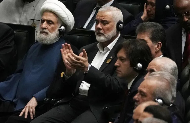 El jefe de Hamas, Ismail Haniyeh, aplaude mientras el recién elegido presidente iraní, Masoud Pezeshkian, habla mientras el líder adjunto del grupo militante libanés Hezbolá, el jeque Naim Kassem, a la izquierda, permanece sentado durante la ceremonia de investidura de Pezeshkian en el Parlamento iraní, en Teherán, Irán, martes 30 de julio de 2024.