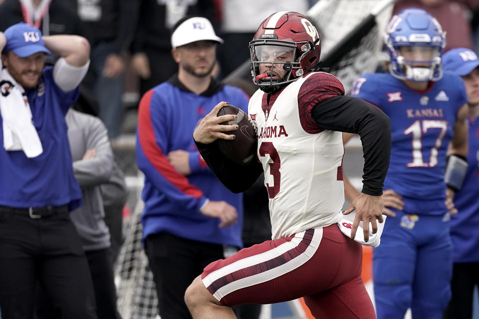 Oklahoma quarterback Caleb Williams (13) celebrates runs 40 yards to score a touchdown during the second half of an NCAA college football game against Kansas Saturday, Oct. 23, 2021, in Lawrence, Kan. Oklahoma won 35-23. (AP Photo/Charlie Riedel)