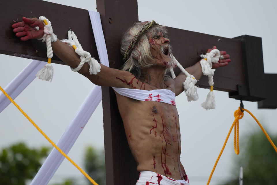 Wilfredo Salvador grimaces after he was nailed to the cross during a reenactment of Jesus Christ's sufferings as part of Good Friday rituals April 7, 2023 in the village of San Pedro, Cutud, Pampanga province, northern Philippines. The real-life crucifixions, a gory Good Friday tradition that is rejected by the Catholic church, resumes in this farming village after a three-year pause due to the coronavirus pandemic.(AP Photo/Aaron Favila)