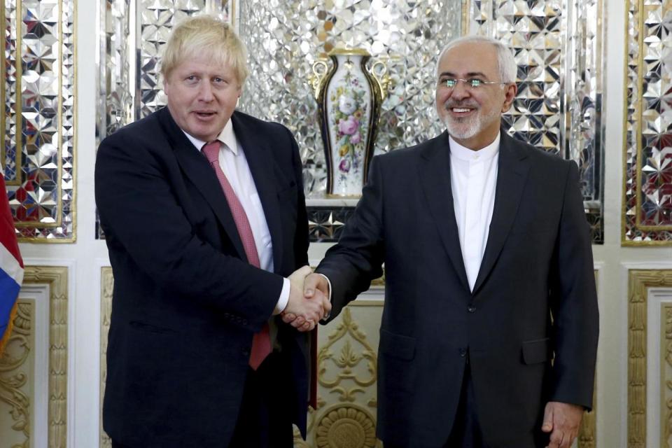 Iranian Foreign Minister Mohammad Javad Zarif shakes the hand of Boris Johnson (AP)