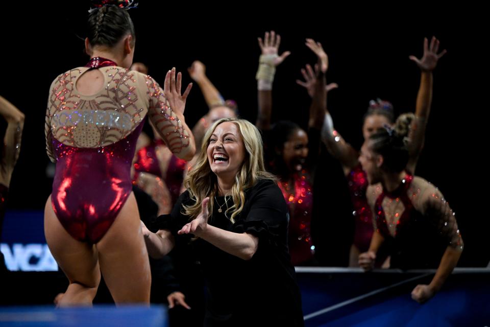 OU coach K.J. Kindler and her team cheer for gymnast Audrey Davis after Davis performed on beam during the NCAA Women's National Gymnastics Tournament Championship at Dickies Arena in Fort Worth, Texas.