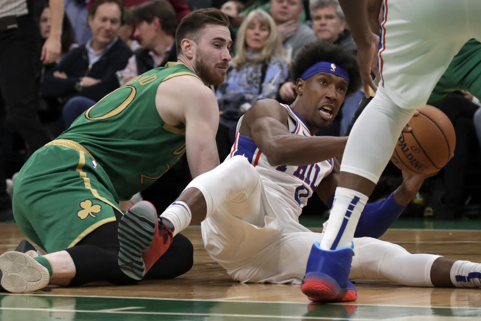 Philadelphia 76ers guard Josh Richardson (0) controls the ball during a floor scramble against Boston Celtics forward Gordon Hayward, left, in the second half of an NBA basketball game, Thursday, Dec. 12, 2019, in Boston. (AP Photo/Elise Amendola)