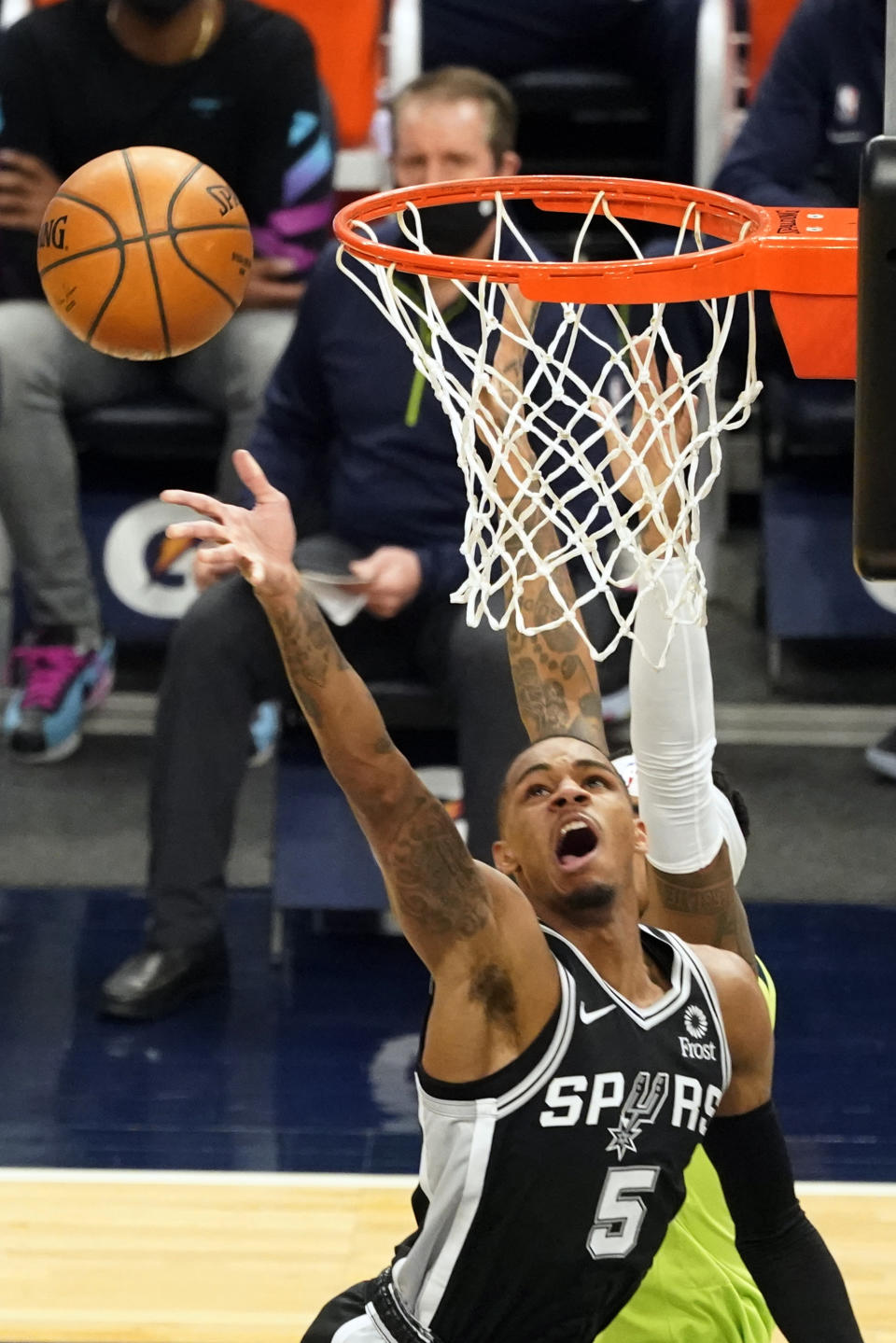 San Antonio Spurs' Dejounte Murray (5) lays up a shot against the Minnesota Timberwolves in the first half of an NBA basketball game Saturday, Jan. 9, 2021, in Minneapolis. (AP Photo/Jim Mone)