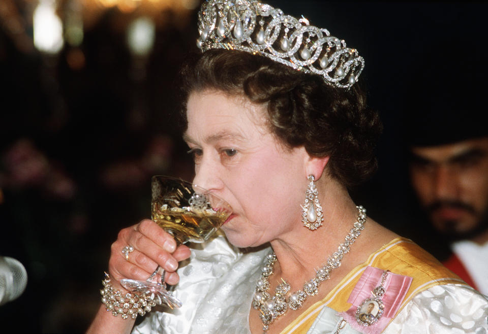 Queen Elizabeth II toasting a drink at the King's banquet in Nepal, 1986. (Photo by Anwar Hussein/Getty Images)