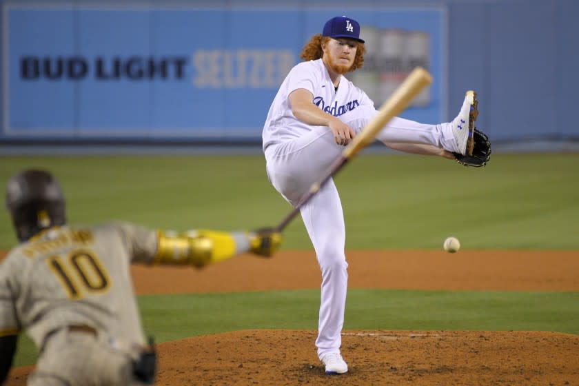 Los Angeles Dodgers starting pitcher Dustin May, right, tires to catch a comeback shot hit by San Diego Padres' Jurickson Profar as Profar grounds out during the fifth inning of a baseball game Monday, Aug. 10, 2020, in Los Angeles. (AP Photo/Mark J. Terrill)