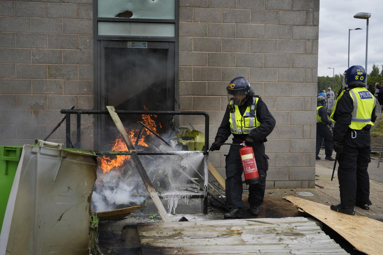 A fire is extinguished by police officers outside the Holiday Inn Express in Rotherham on Sunday. (PA)